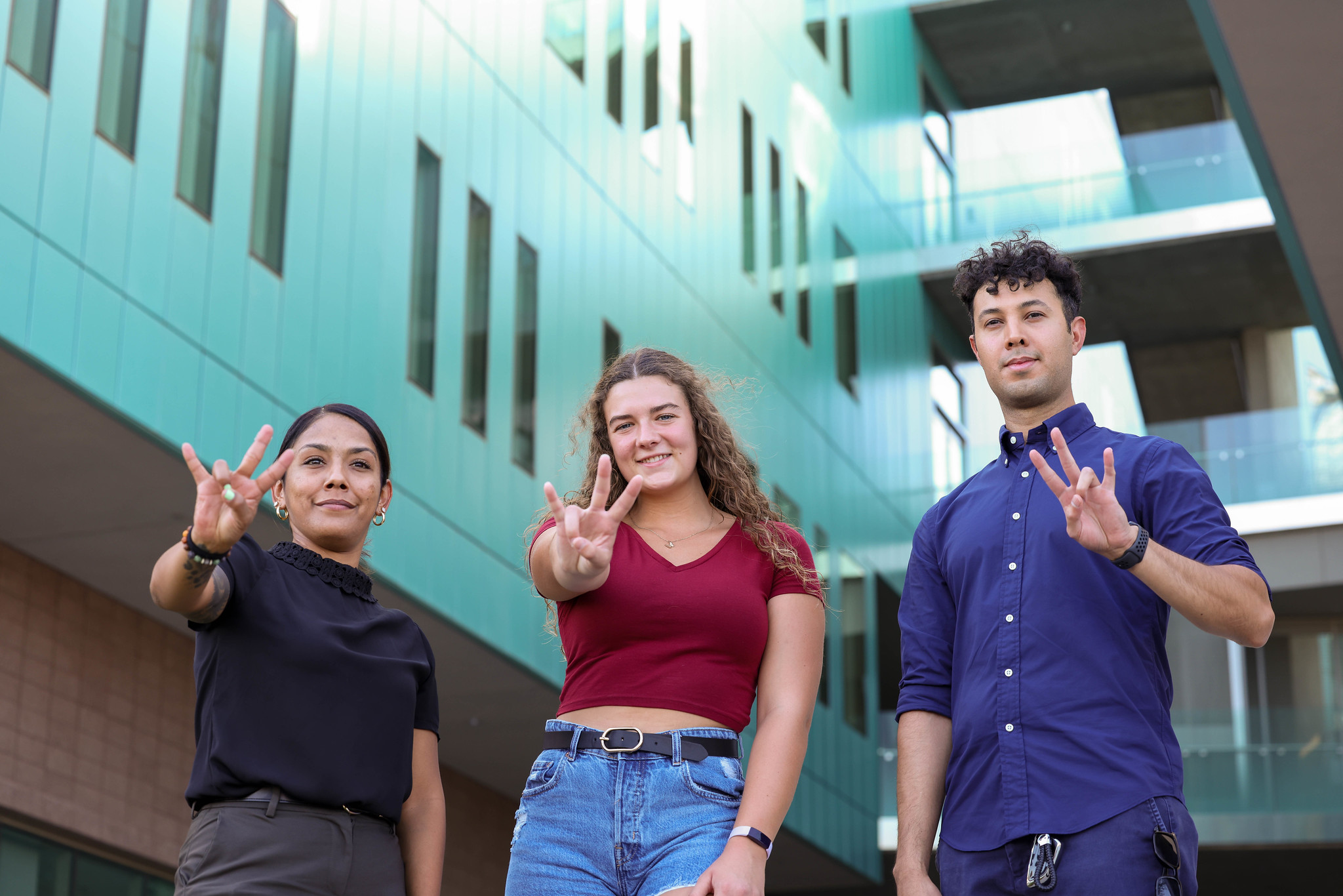 three students outside posing for photo