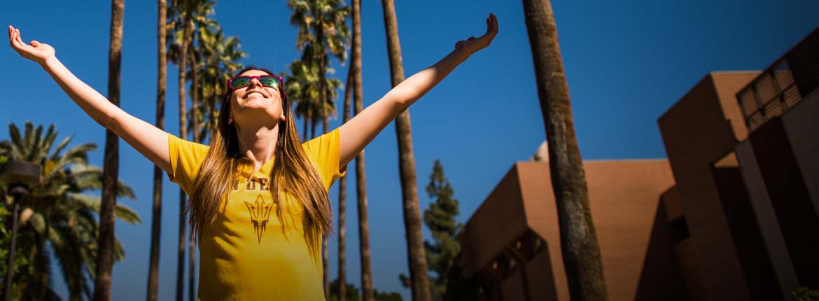student wearing an ASU gold shirt on palm walk